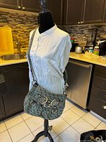 Guess shoulder bag on mannequin showing the front and strap
