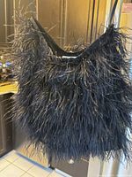 Front view of black ostrich feather skirt showing texture and feather details