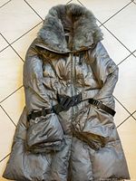 Front view of the silver puffer coat showing fur-lined collar, belt and buckle cuffs