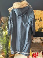 Back view of blue overcoat shell showing full length and white fox fur trimmed hood