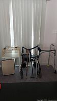 Full view of all accessibility aid items including two walkers, canes, TV tables, and other assistive tools.