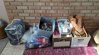 Overview of all knitting, yarn and needlepoint supplies showing various bags, bins, and baskets with materials and tools.