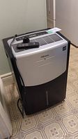 Photo showing the Danby Premiere dehumidifier unit with power cord and remote control on top.