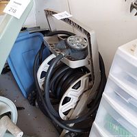 Side view of the coiled black hose on beige plastic Suncast caddy.