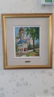 Framed painting showing Old Quebec scene with buildings and trees.