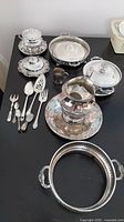 Full overview of silver plate collection including utensils, jug, small cup, covered serving dishes, and tray.