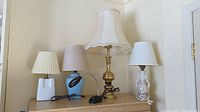 Photo showing all five lamps arranged on a dresser, showcasing different shapes and lampshades.