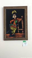 Full view of the framed velvet painting showing Goofy in a cowboy sheriff outfit against a black background with a wooden fence, signed on bottom left.