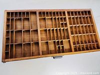 Top view of wooden letterpress typeset drawer showing multiple compartments