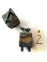 Top-down and side view of two square raku pottery vessels with lids showing textured earthy finish and sculptural handles.