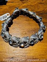 Vintage silver-tone Coro ornate bracelet laid flat showing full bracelet and stamped mark.