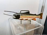 Side angled view of the hand painted wooden salmon on metal stand showing front and side details.