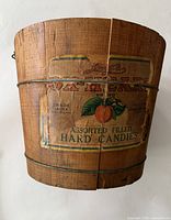 Front view showing worn label and vintage wood bucket with wire bands.