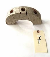 Overall view of the arch-shaped travertine candelabra showing the three candle holes and stone texture.