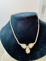 Full view of the necklace displayed on a black velvet bust, showing overall design and length.