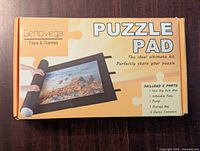 Front of the sealed box showing product name, brand Genovega, and contents included: non-slip felt mat, inflatable tube, pump, storage bag, elastic fasteners