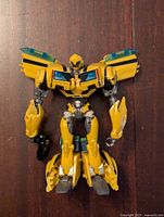 Bumblebee figure in robot mode showing yellow and black design with blue accents on chest and articulated arms and legs.