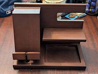 Front view of the wooden organizer showing slots and compartments for phone and watch