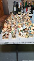 Assorted Hummel figurines arranged on table, front view showing various models