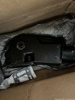 Black metal/cast Aqua Power 5705 boat part inside a cardboard box with packaging material