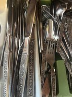 Close-up of knives and forks showing floral patterned handles