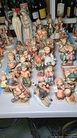 Group shot showing all porcelain Hummel figurines on display, various child and religious pieces