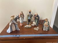 All porcelain figurines arranged on wood surface