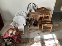 Photo showing all chairs and racks grouped together including wicker chairs, wooden chairs, luggage and racks.