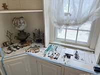 Wide view of countertop displaying assorted jewelry, lamp, and display stands