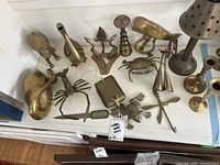 Top view of a collection of vintage copper figurines including frog, crab, lobster, and others, displayed on a white surface.