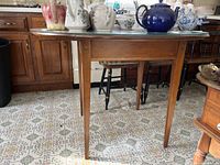 Side view of glass top kitchen table showing the wooden base and table legs.