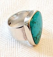 Front and angled view showing the natural turquoise stone set in sterling silver band, highlighting stone color and veining.