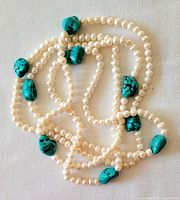 Image showing the necklace coiled with visible turquoise nuggets and freshwater pearls.