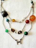 Partial close-up of the necklace showing color variety of natural stone beads and chain links.