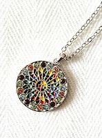 Close-up of the round pendant showing the colorful crystal stained glass window design.