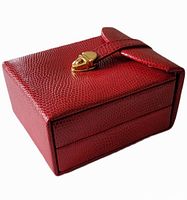 Closed red jewelry case with textured exterior and gold-tone clasp