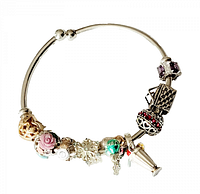 Full view of sterling silver bangle bracelet with nine decorative beads showing various designs and colors including gold-tone filigree, pink rose, and silver snowflake.