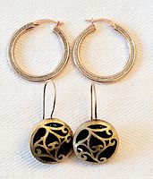 Two pairs of earrings: rose gold plated hoops on top, yellow gold plated drop earrings with black glass centers below.