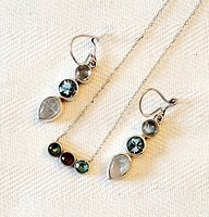 Close-up of necklace and earrings showing details of gemstones and silver bezels