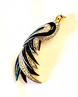 Front view of the brooch showing bird shape with blue and green enamel and clear crystals with red eye.