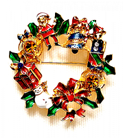 Front view of the vintage Christmas wreath brooch with colorful enamel Christmas-themed figures and amber crystals, showing detailed design and colors.