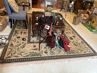 Top-down angle showing the floral pattern and full coverage of the rug under a coffee table with other furniture around.
