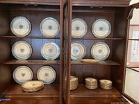 Cabinet shelf with stacks of plates: dinner, salad and bread plates.