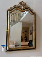 Full front view of rectangular mirror showing carved gilt frame and bow crest