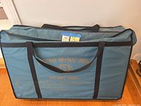 Closed green fabric carrying case with black handles, showing printed gold text 'Richway Bio-Mat 2000MX' and company info.