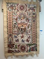 Full front view of the tapestry hung on the wall, showing the entirety of the piece along with side tassels.
