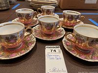 Six tea cups and saucers arranged on table