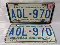Front view of two New Brunswick license plates with registration AOL-970 and dated 03/90, showing wear and rust.