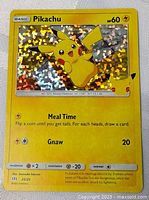 Front holographic yellow Pikachu Pokémon card with shiny holo foil background showing Pikachu in a playful pose.
