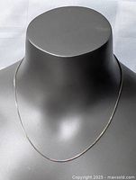 Sterling silver necklace displayed on a mannequin bust showing the chain design and length.